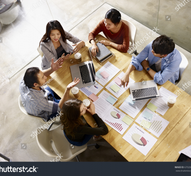 stock photo high angle view of a team of asian and caucasian corporate executives discussing business