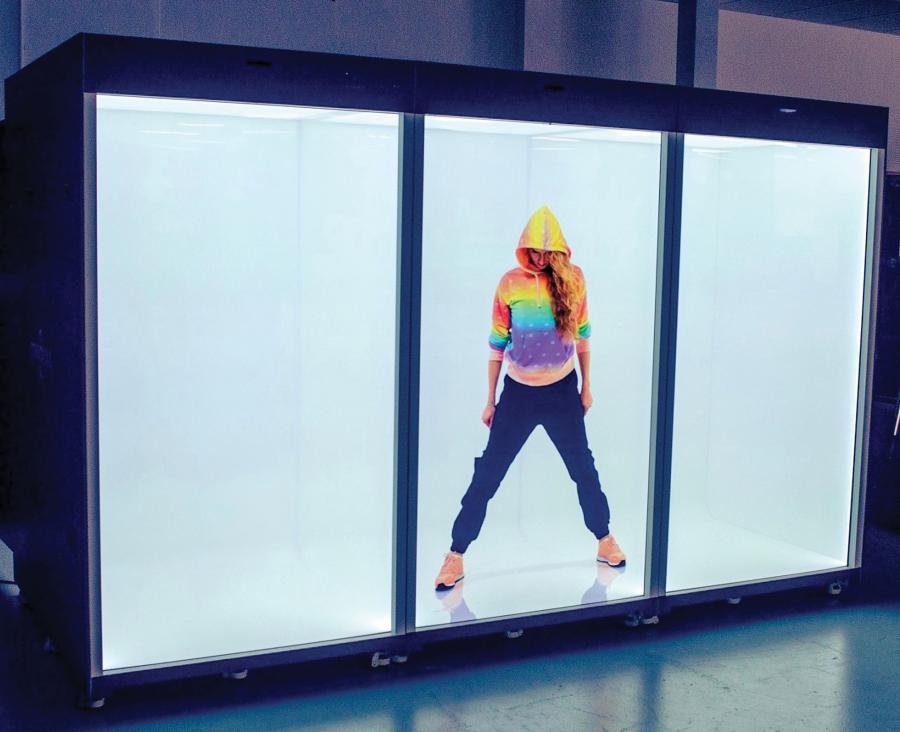A three-grid square holographic display with a 3D image of a woman wearing a rainbow-colored hoodie, looking down with hoodie hiding her face in a wide-stance pose