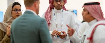 Grupo de asistentes habla entre sí en la Cumbre Comercial de Oriente Medio de IAAPA.