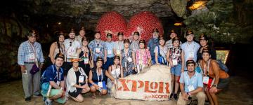 Photo de groupe des membres de l'IAAPA Amérique latine et Caraïbes posant à l'intérieur d'une grotte lors de l'IAAPA Explores LAC