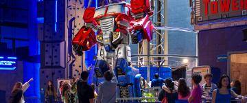 Les invités pointent et regardent le tour Optimus Prime Tower à l’intérieur de Hasbro City