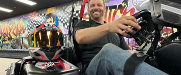 Jordan Munsters sits in a handicapable go-kart with a hand control system