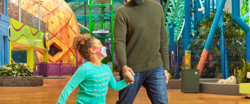 Mall of America - Nickelodeon Universe - Padre e figlia che camminano accanto a un enorme ananas
