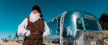 Père Noël au Skypark debout devant un camping-car