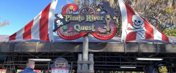 Pirate River Quest ride entrance sign. It is designed to look like a ship mast.