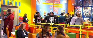 Un groupe d'adultes vêtus de différents costumes à l'intérieur du Legoland Discovery Center de Chicago pour son événement Adult Night