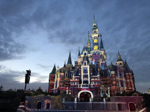 Shanghai Disneyland Resort illuminated at night with projection mapping