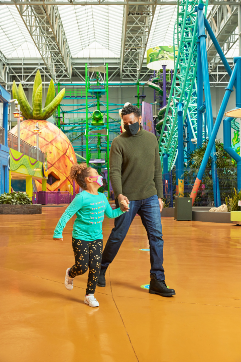Mall of America - Nickelodeon Universe - Pai e filha caminhando por um enorme abacaxi
