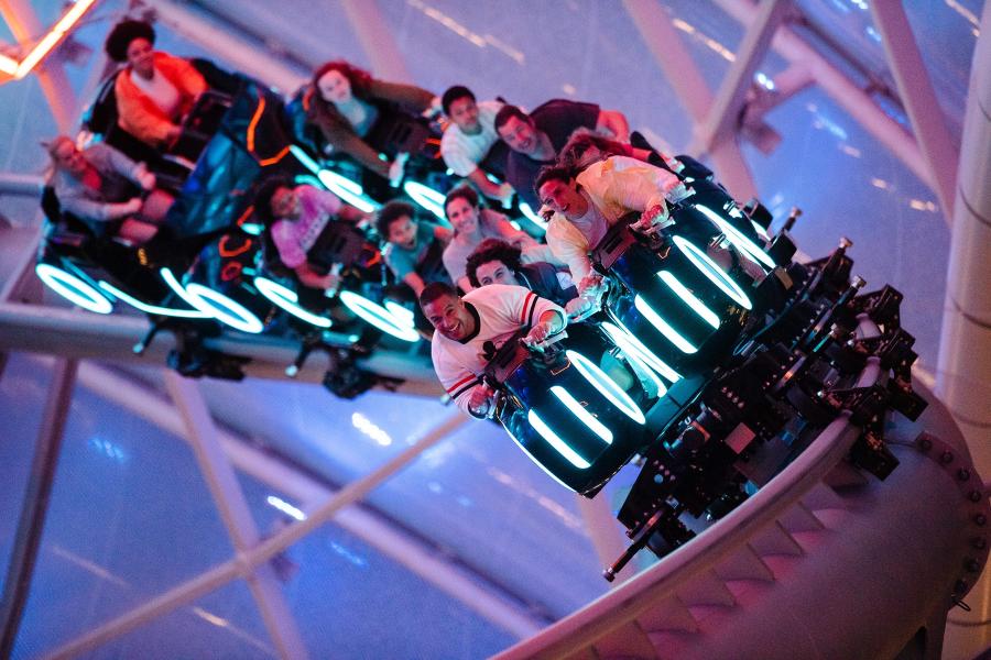 Riders react as they emerge outside during the initial launch of Tron Lightcycle Run