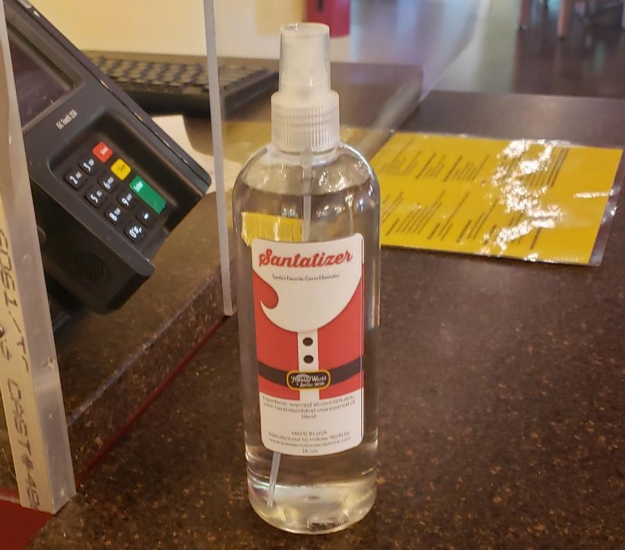 Una botella de spray de desinfectante para manos con la marca Santa
