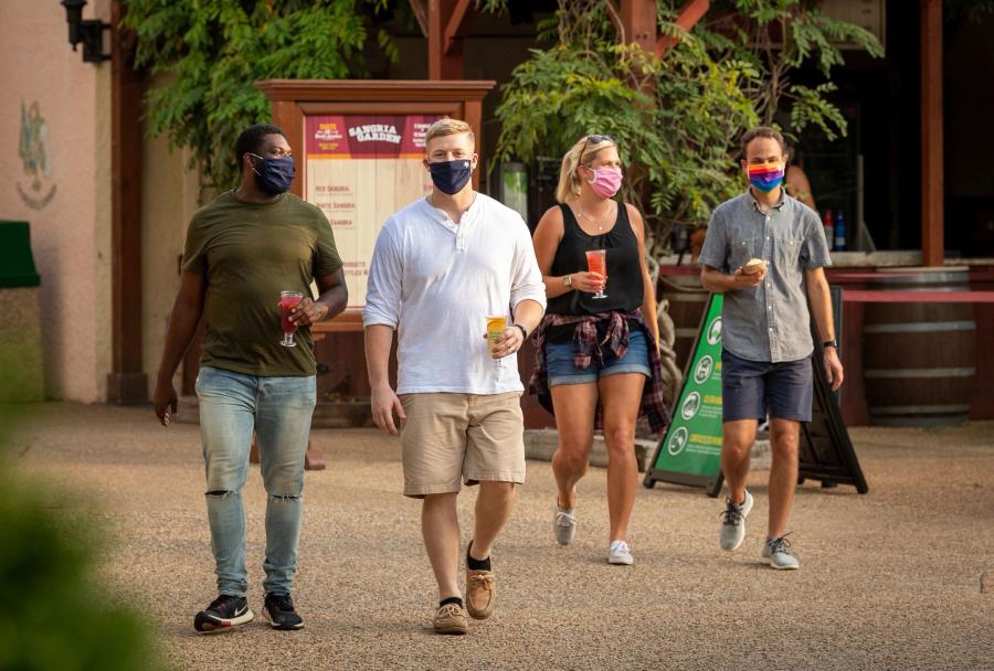 Guests wearing masks enjoying a theme park.