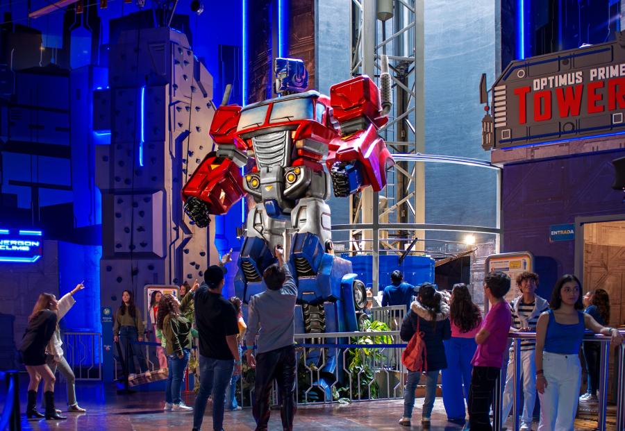 Guests point and look at Optimus Prime Tower ride inside Hasbro City