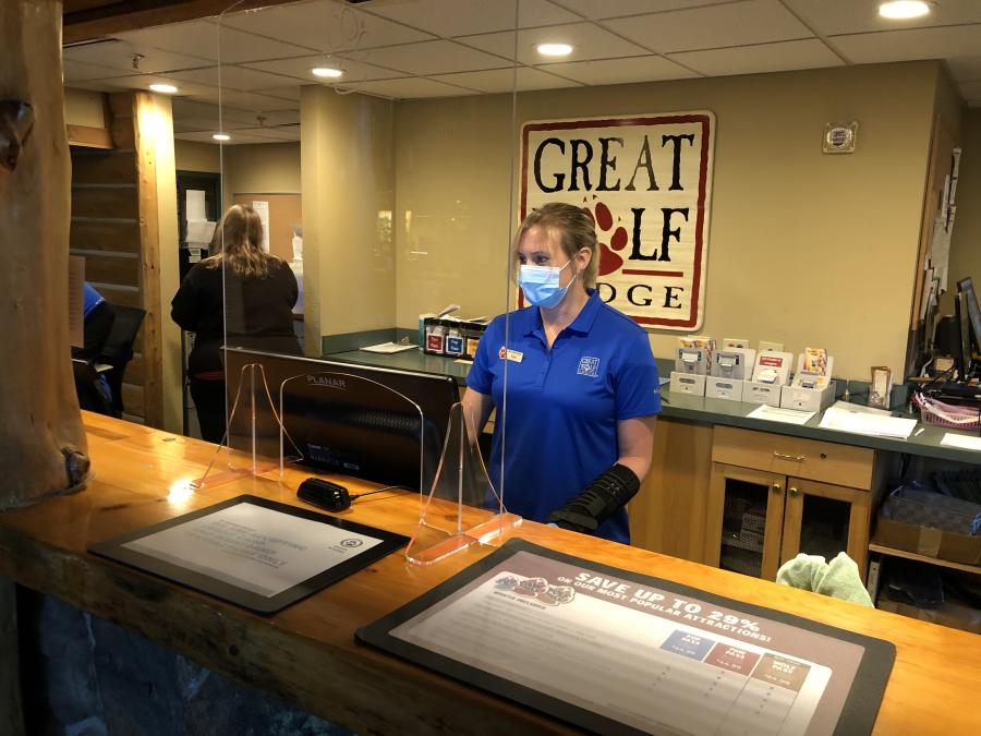 Staff stands behind a plexiglass barrier at reception at Great Wolf Lodge