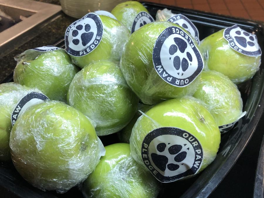 Apples in plastic wrap with paw sticker