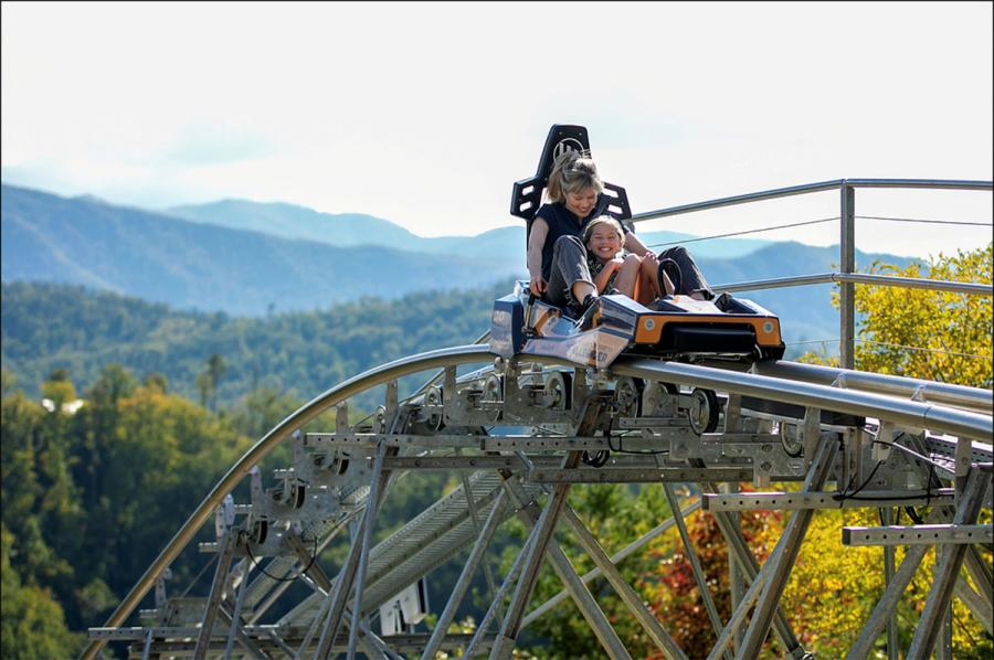 Um adulto e uma criança andam no assento inline Hellbender Coaster