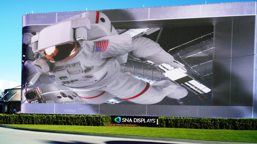 A massive LED screen built at the entrance of the Kennedy Space Center Visitor Complex, showing 3D animations of an astronaut reaching toward the screen