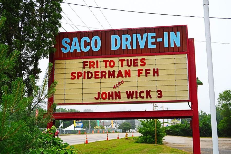 Movie theater marquee sign for Saco Drive-In, located in Maine. Marquee sign text: Fri to Tues, Spiderman FFH and John Wick 3