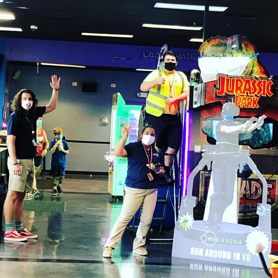 Le personnel de la FEC portant des masques posant dans une salle d'arcade