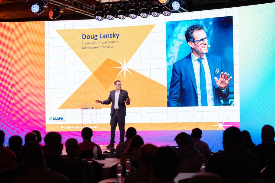 Doug Lansky, a travel writer and tourism development advisor, is on stage delivering his presentation at IAAPA North America Summit 2024 in Las Vegas