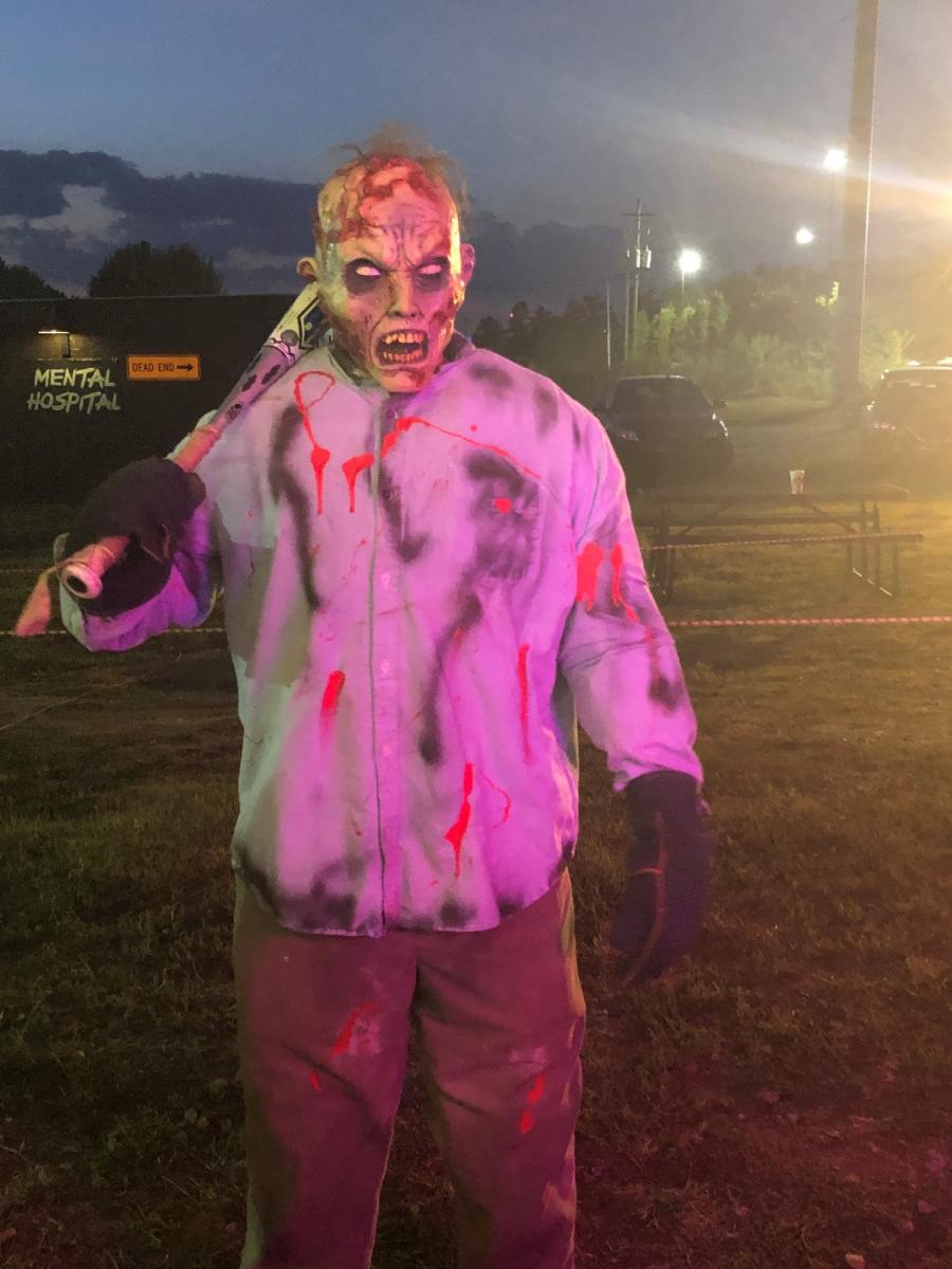 Un personaje zombi con sangre en su as posa amenazadoramente para la cámara.