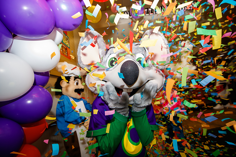 Chuck E. Cheese surrounded by confetti 