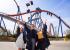 Tres graduados universitarios lanzan sus gorras al aire celebrando sus títulos del programa de gestión de atracciones y complejos turísticos de la Universidad Estatal de Bowling Green.
