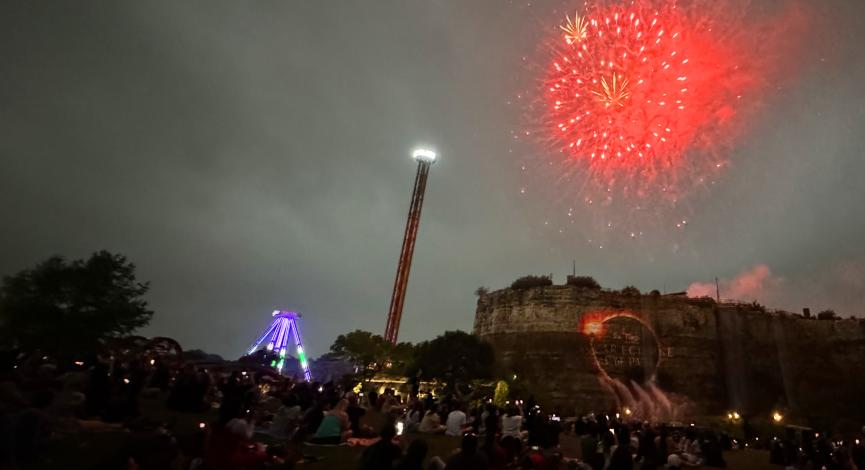 Fireworks illuminate the sky in the middle of a solar eclipse at Six Flags Fiesta Texas in San Antonio