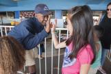 Um funcionário do Santa Cruz Beach Boardwalk cumprimenta um jovem hóspede que espera na fila da atração de carrinhos de bate-bate