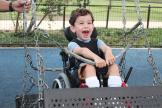 Un bambino su una sedia a rotelle gioca su un'altalena accessibile al parco acquatico Morgan's Wonderland