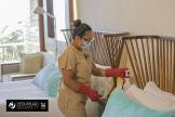 Staff at a Grupo Xcaret hotel cleans a room wearing PPE in a branded photo