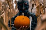 person wearing mask holding pumpkin horizontal2