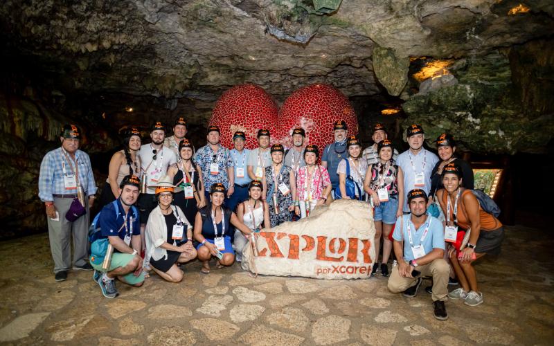 Foto grupal de miembros de IAAPA América Latina y el Caribe posando dentro de una cueva durante IAAPA Explora LAC