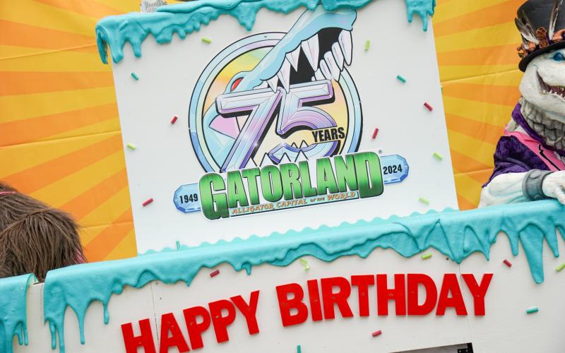A giant wooden cake at Gatorland's entrance that says "Happy Birthday".